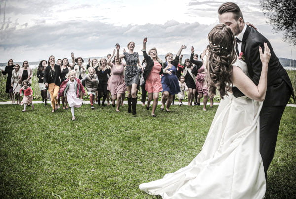 Wedding couple with joyful guests at wedding | Mywayphoto